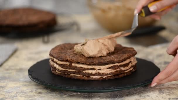 Schokoladenschichten aus Napoleonkuchen zu Hause herstellen: Pudding auf gebackenem Teig. — Stockvideo