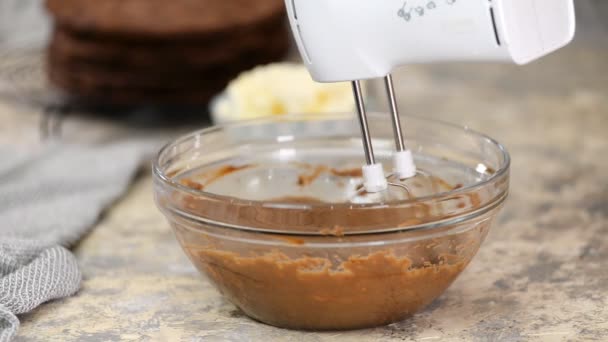 Whipping by a mixer of butter with chocolate. Making brown chocolate cream for the cake. — Stock Video