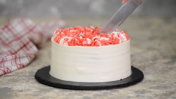 Das Messer schneidet ein Stück leckeren Kirschkuchen mit rosa Sahne. — Stockvideo