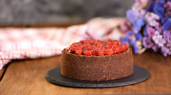 Nydelig hjemmelaget sjokoladeostekake dekorert med kirsebærsaus. – stockfoto