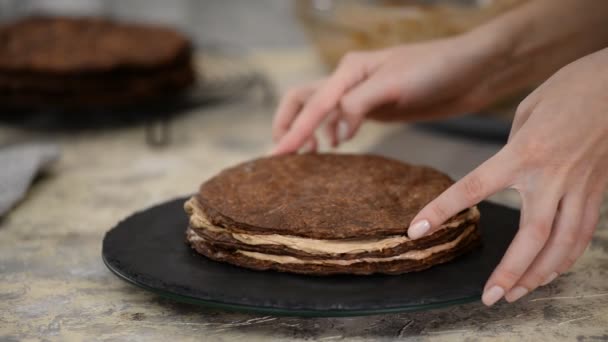 Fare strati di cioccolato di torta napoleonica a casa: mettere la crema pasticcera sulla pasticceria al forno . — Video Stock