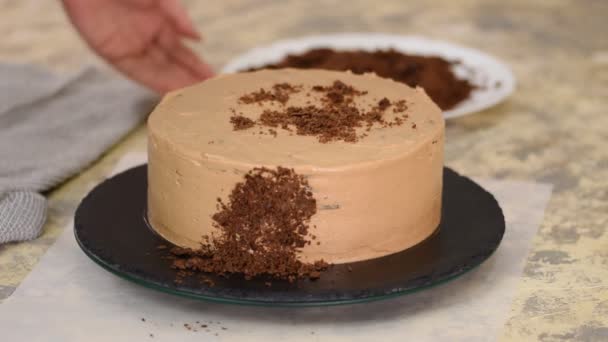 Posypywanie ciasta czekoladowego okruszkami. Pokrycie tortu napoleońskiego okruszkami. Proces gotowania, desery przepis. — Wideo stockowe