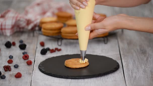 Banketbakker maakt French Mille Feuille met vla en bessen. Frans dessert millefeuille van bladerdeeg en vla crème. — Stockvideo