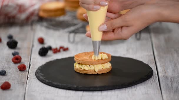 Bakverk kock gör franska Mille Feuille med vaniljsås och bär. Fransk dessert millefeuille av smördeg och vaniljkräm. — Stockvideo