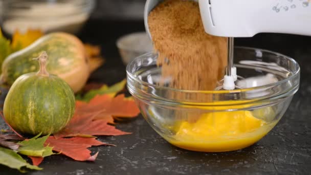 Woman hand beating eggs with brown sugar in bowl. — Stock Video