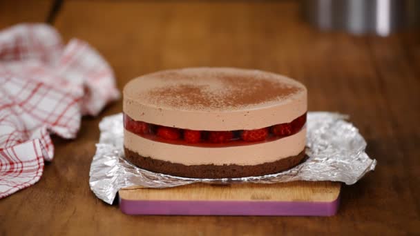 Desempolvar un delicioso pastel de mousse de chocolate con cacao en polvo . — Vídeo de stock