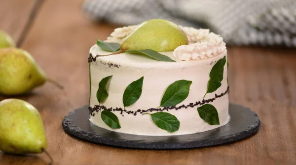 Gâteau à la crème décoré de poire fraîche et de feuilles vertes . Image En Vente