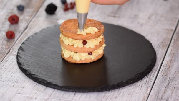 Konditor macht französische Mille Feuille mit Pudding und Beeren. französisches Dessert millefeuille aus Blätterteig und Puddingcreme. — Stockvideo