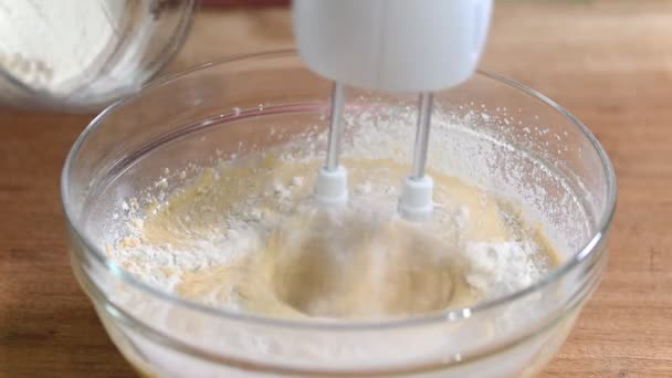 Lägga mjöl i skålen och blanda den med elektrisk mixer. — Stockvideo