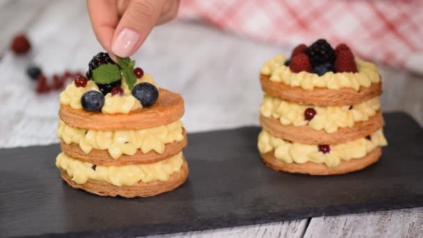 Bakverk kock gör franska Mille Feuille med vaniljsås och bär. Fransk dessert millefeuille av smördeg och vaniljkräm. — Stockvideo