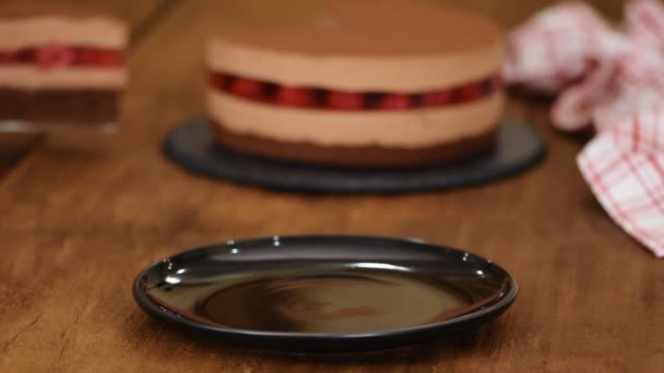 Piece of delicious chocolate mousse cake with raspberries jelly. — Stock Video