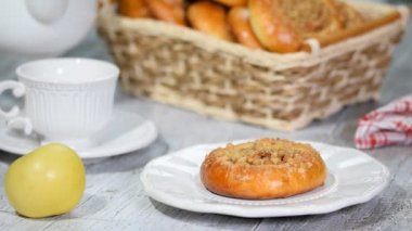 Bir fincan çay ve elma dolgulu lezzetli çörek. Bir fincana çay dolduruyorum..