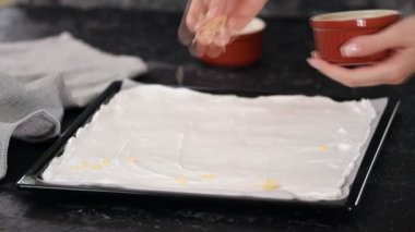 Pasta şefi kremalı pasta yapar, badem ezmesi serpiştirir..