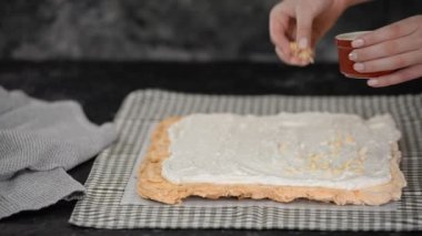 Pasta şefi kremalı pasta yapar, badem ezmesi serpiştirir..