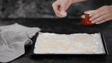 Pasta şefi kremalı pasta yapar, badem ezmesi serpiştirir..