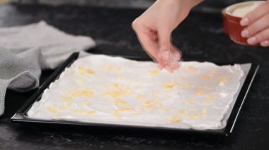 Pasta şefi kremalı pasta yapar, badem ezmesi serpiştirir..