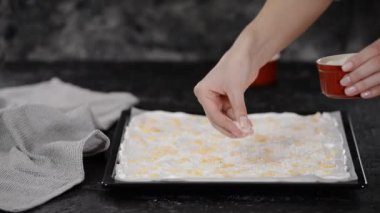 Pasta şefi kremalı pasta yapar, badem ezmesi serpiştirir..