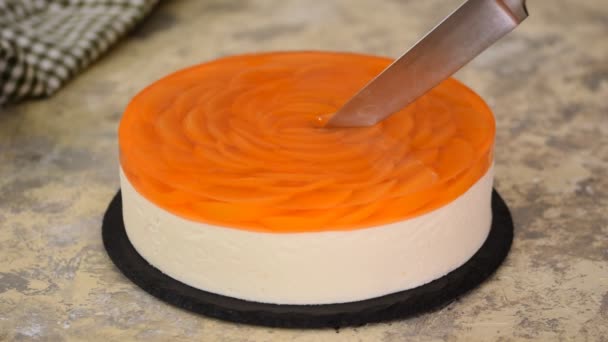 Fruit cake with peach, jelly and mousse. Woman hands cutting peach mousse cake. — Stock Video