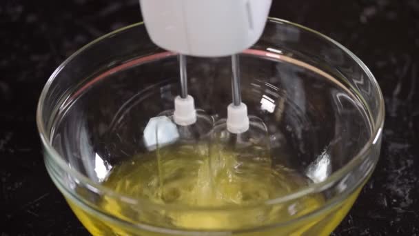Mains battant les blancs d'œufs crème avec mélangeur dans le bol . — Video
