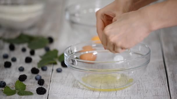 Woman separating egg yolk from white in kitchen, close-up. — ストック動画