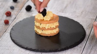 Pasta şefi krema ve böğürtlenli Fransız Mille Feuille yapıyor. Fransız tatlı millefeuille puf böreği ve krema.