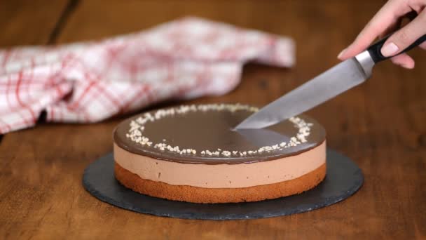 Ręce cukiernika pokrojone nożem ciasto czekoladowe mus — Wideo stockowe