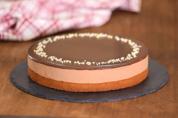 Delicious chocolate mousse cake decorate with nuts on the top.