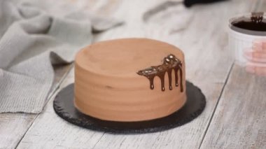 Erimiş çikolatayla çikolatalı pasta. Pastanın üstüne çikolata döken kadın. Ev yapımı kakaolu kek..