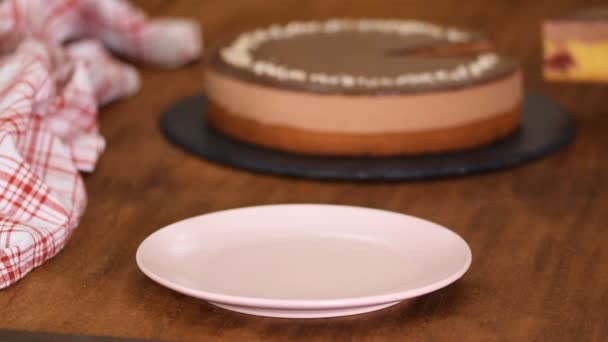 Pedazo de pastel de mousse de cereza de chocolate en un plato rosa . — Vídeos de Stock