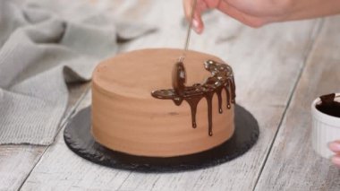 Erimiş çikolatayla çikolatalı pasta. Pastanın üstüne çikolata döken kadın. Ev yapımı kakaolu kek..