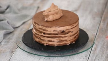 Kadın, pastanın üstüne son çikolata şekerini ekliyor..