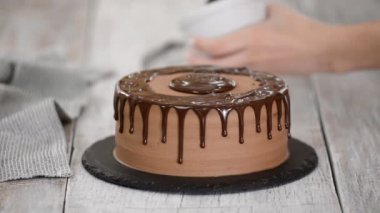 Erimiş çikolatayla çikolatalı pasta. Pastanın üstüne çikolata döken kadın. Ev yapımı kakaolu kek..