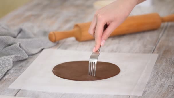 Женщина протыкает тесто вилкой, чтобы предотвратить пузырьки воздуха во время выпечки . — стоковое видео