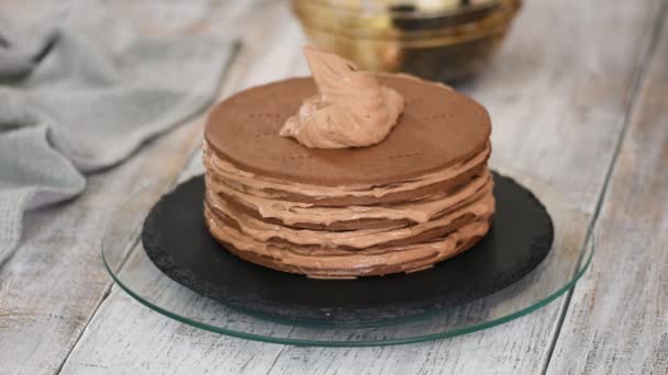 Paso a paso. Pastelero haciendo pastel de capa de chocolate con relleno de ciruelas pasas. Pastelero pone crema encima de la torta . — Vídeos de Stock