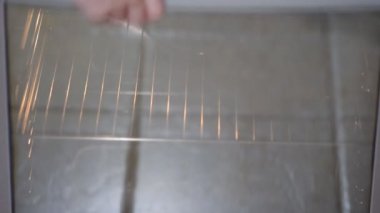 Kadın elleri fırına çiğ kek koyar..