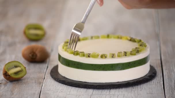 Chef decorar o bolo com kiwi fresco. Bolo de mousse caseiro com kiwi . — Vídeo de Stock