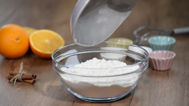 Mixing flour with spices. Female hands mixing in bowl flour with orange zest, cinnamon and dry yeast. — Stock Video