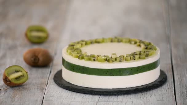 Chef decorar o bolo com kiwi fresco. Bolo de mousse caseiro com kiwi . — Vídeo de Stock