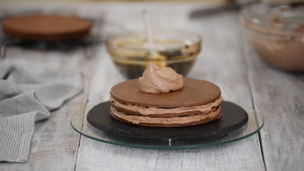 Paso a paso. Pastelero haciendo pastel de capa de chocolate con relleno de ciruelas pasas. Pastelero pone crema encima de la torta . — Vídeos de Stock