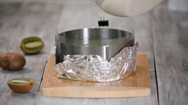 Ev yapımı mus kek yapmak. Beyaz çikolata mousse formda dökme.