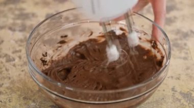 Pasta için krema yapma süreci. Pasta şefi çikolatalı kremayı mikserle dövüyor..
