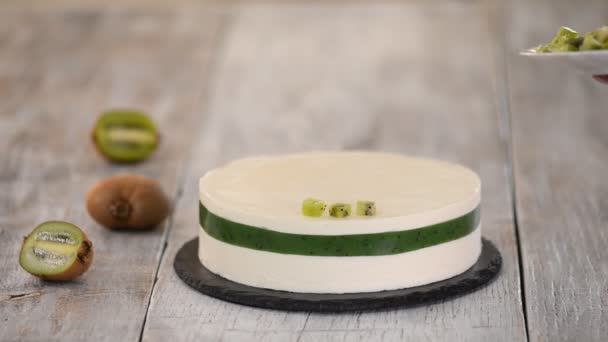 Chef decorar o bolo com kiwi fresco. Bolo de mousse caseiro com kiwi . — Vídeo de Stock