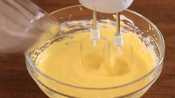Close up of cookie or cake batter ingredients of dry flour mix, egg and butter in mixing bowl. — Stock Video