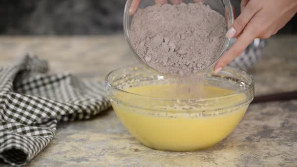 Añadiendo harina al bateador. Ingredientes secos plegables de las manos del chef a la masa . — Vídeo de stock