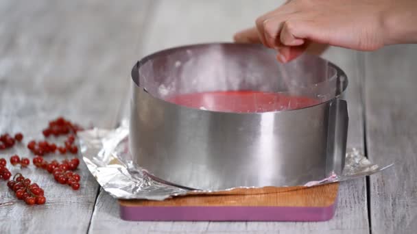 Chef elimina un molde de anillo de metal de un pastel de mousse de grosella roja . — Vídeo de stock