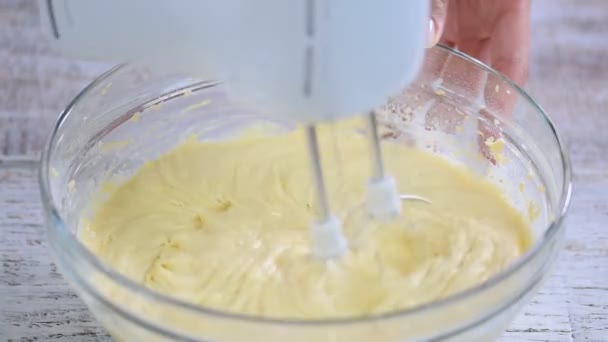 Pastella torta mescolato con un mixer in una ciotola di vetro . — Video Stock