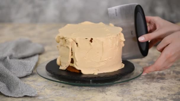 Aligner la crème au caramel avec une palette à pâtisserie sur un gâteau aux biscuits. Cuisson d'un gâteau au biscuit au caramel. Confiserie de maison . — Video