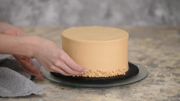 Cocinero pastelero decorando el pastel de caramelo con un maní . — Vídeos de Stock