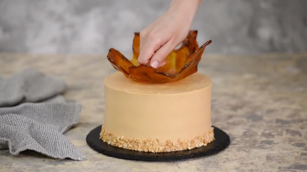 Cocinero pastelero decorando el pastel de caramelo con un maní . — Vídeos de Stock