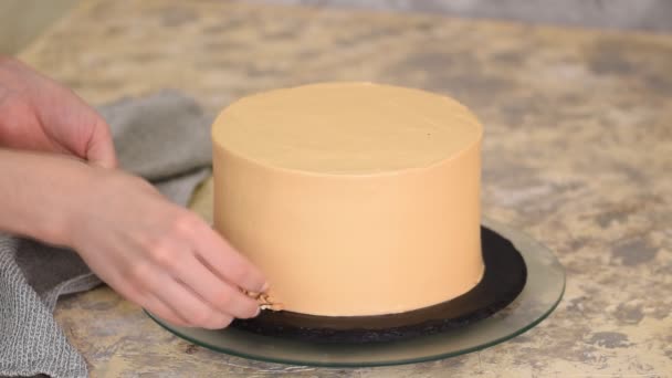 Cocinero pastelero decorando el pastel de caramelo con un maní . — Vídeos de Stock